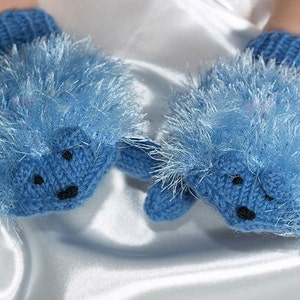 May include: A pair of blue knitted baby mittens with fuzzy trim, shaped like hedgehogs. The mittens have black eyes and noses.