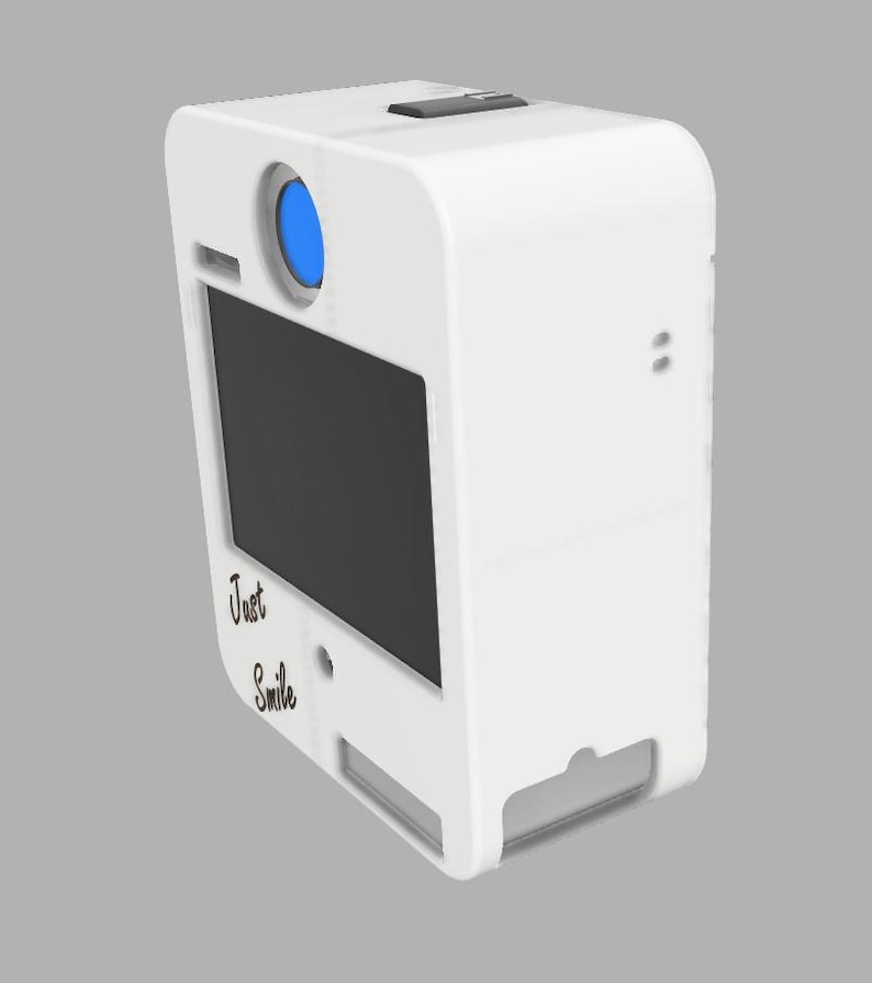 May include: A white photo booth with a black screen and a blue lens. The words "Just Smile" are written on the front. The photo booth has a rectangular shape with rounded edges.