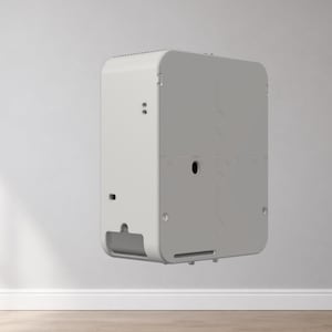 Puede incluir: Un dispositivo blanco rectangular con esquinas redondeadas, montado en una pared gris claro. El dispositivo tiene una parte superior perforada, una abertura circular y una ranura rectangular en la parte inferior. El dispositivo est&aacute; flotando en el aire.