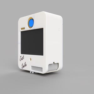 May include: A white photo booth with a black screen, a blue lens, and the words "Just Smile" in script. The booth has a rectangular shape with rounded edges and a small slot for photos.