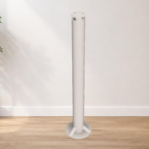 May include: A tall, white, cylindrical object with a circular base and a decorative top. The object stands on a wooden floor against a white wall. A potted plant is visible in the background.