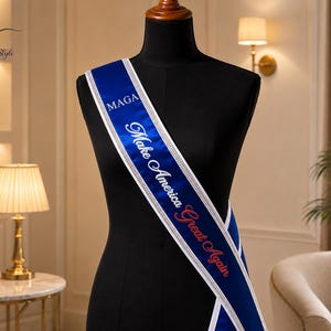 May include: A royal blue satin sash featuring the white text MAGA and the text Make America Great Again in white and red lettering. The sash is bordered by two thin, shimmering silver rhinestone trim strips running along both edges.