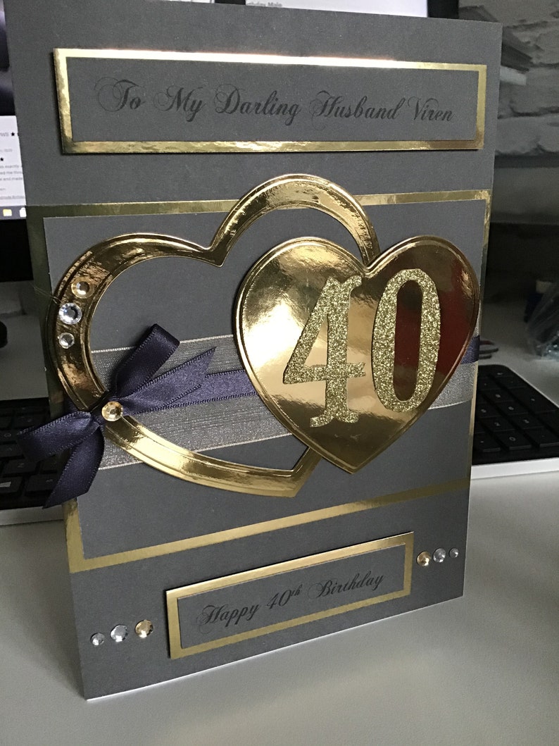 May include: A gray card with gold accents and a large gold heart with the number 40 in glitter. The card says "To My Darling Husband Viren" and "Happy 40th Birthday".