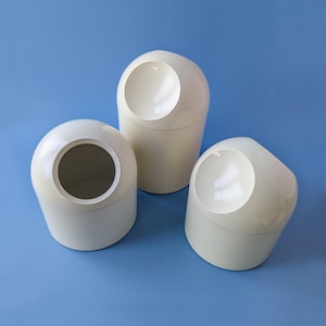 Peut inclure: Trois récipients cylindriques blanc cassé avec des couvercles arrondis en forme de dôme dotés d'une ouverture circulaire. Les récipients ont une finition lisse et brillante et sont disposés en groupe, avec une unité plus haute derrière deux plus courtes.