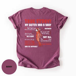 Pode incluir: Uma t-shirt de manga curta cor de baga com um gráfico de um camarão de desenho animado e o texto: TRUE STORY! MY SISTER HAD A BABY AND I TOOK IT OVER BECAUSE SHE PASSED AWAY BECAUSE THE SECOND SHIFT AT THE FACTORY AND ITS ARMS AND NOW ITS NOTHING BUT A STUMP BUT ALL THE THAT I SEE IN THAT LITTLE GUYS FACE OF IT WITH MY WIFE AND TRUE STORY! AND ITS DIFFICULT.