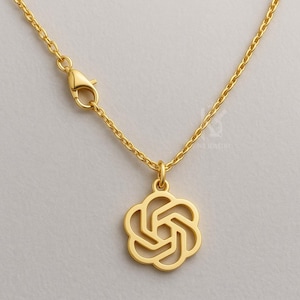 Puede incluir: Un collar dorado con una cadena delicada y un colgante con forma de flor estilizada. El colgante presenta un diseño calado con líneas curvas. El collar tiene un cierre de mosquetón.