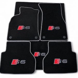 Può includere: Set di cinque tappetini neri per auto con bordi bianchi. Ogni tappetino presenta il logo "S6" rosso e bianco. Questi tappetini sono progettati per proteggere l'interno dell'auto da sporco e usura.