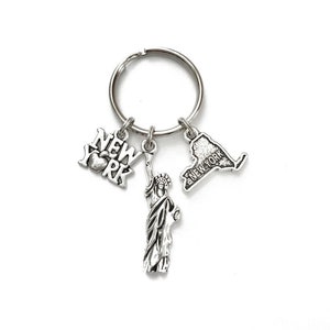 New York themed keychain. Includes Includes New York State, New York Sign with Apple, and Statue of Liberty.
