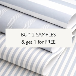 May include: Rolled wallpaper samples with a light blue and white striped pattern. The text "BUY 2 SAMPLES & get 1 for FREE" is displayed on a white rectangular label.