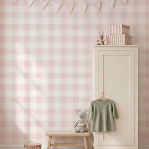 May include: A tall off-white wooden wardrobe with a single door, topped with two stacked striped boxes and a small rabbit figurine. A light green knit dress hangs on the door handle, while a plush mouse sits on a wooden bench nearby.