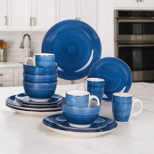 Könnte beinhalten: Ein komplettes blau-weißes Geschirrset. Das Set beinhaltet Teller, Schalen und Tassen. Die blauen Teile haben ein Spiraldesign. Die Tassen und Schalen haben eine weiße Innenseite. Die Teller haben einen weißen Grund mit blauem Rand.