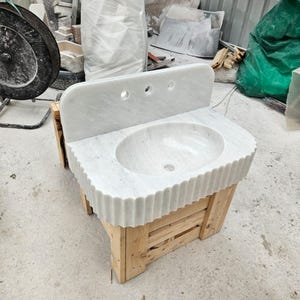 May include: A set of three ceramic mugs with a speckled, matte finish. The mugs are in shades of cream, light gray, and dark gray. Each mug has a simple, minimalist design, perfect for coffee or tea.