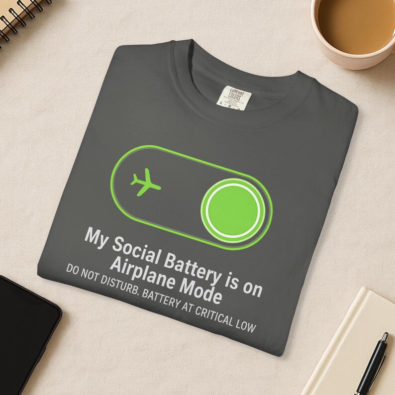 Puede incluir: Camiseta gris oscuro con un gr&aacute;fico verde de modo avi&oacute;n y el texto "My Social Battery is on Airplane Mode. Do Not Disturb. Battery at Critical Low."
