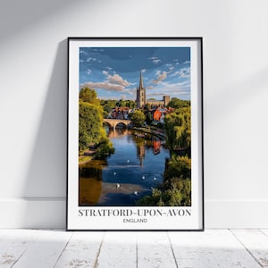 May include: A framed print depicting Stratford-upon-Avon, England, with a river, bridge, and church. The print is in a black frame, leaning against a white wall. The text "STRATFORD-UPON-AVON ENGLAND" is displayed at the bottom of the print.