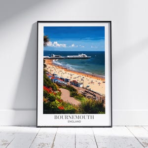 Può includere: Stampa incorniciata di Bournemouth, Inghilterra, con una scena di spiaggia con un molo che si estende nell'oceano blu. L'immagine include una spiaggia sabbiosa, cabine colorate e una vegetazione verde lussureggiante. Il testo "BOURNEMOUTH ENGLAND" è in basso.