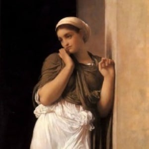 May include: A woman in a white gown and brown shawl stands near a pillar. She is wearing a white head covering and has her hand on her chin. The background is a dark brown.