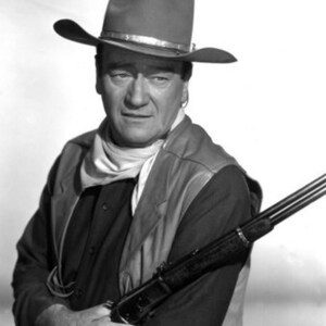 Puede incluir: Una fotografía en blanco y negro de un hombre con un sombrero de vaquero y un chaleco, sosteniendo un rifle.