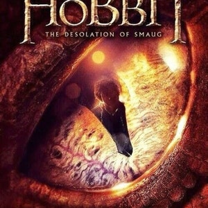 May include: A movie poster for "The Hobbit: The Desolation of Smaug" featuring a close-up of Smaug's eye with Bilbo Baggins looking into it.