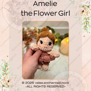 May include: A handmade crochet doll named "Amelie the Flower Girl" with brown hair and a pink dress. The doll is held in a hand. The image includes the text "© 2026 vales.enchanted.hook -ALL RIGHTS RESERVED-".