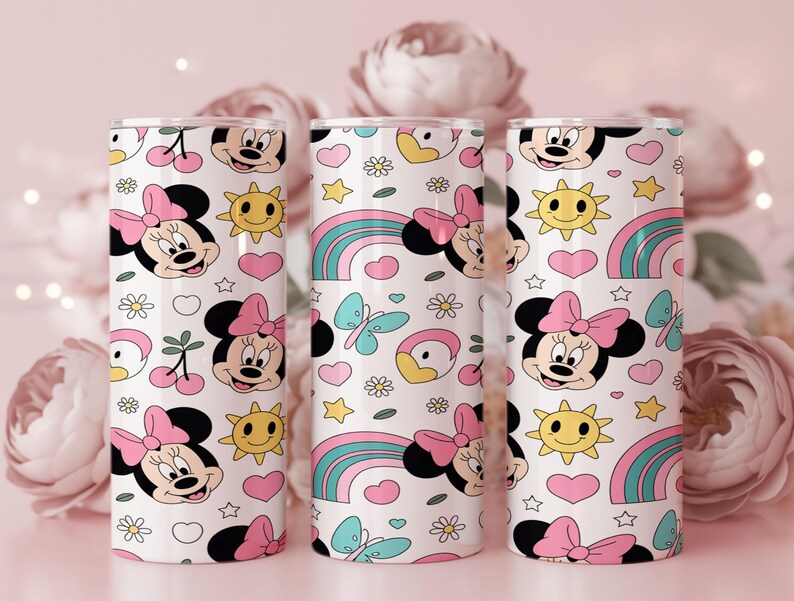Pu&ograve; includere: Tre bicchieri cilindrici con un motivo ripetuto su sfondo bianco. Il design include volti di Minnie con fiocchi rosa, soli gialli sorridenti, cuori rosa, farfalle blu, arcobaleni e piccoli fiori bianchi.