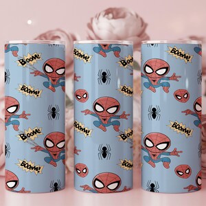 May include: Three blue tumblers featuring a repeating pattern of the Spider-Man character, spider webs, and the word "BOOM!" in yellow starbursts. The tumblers have a silver rim and lid, and are decorated with a cartoon style.