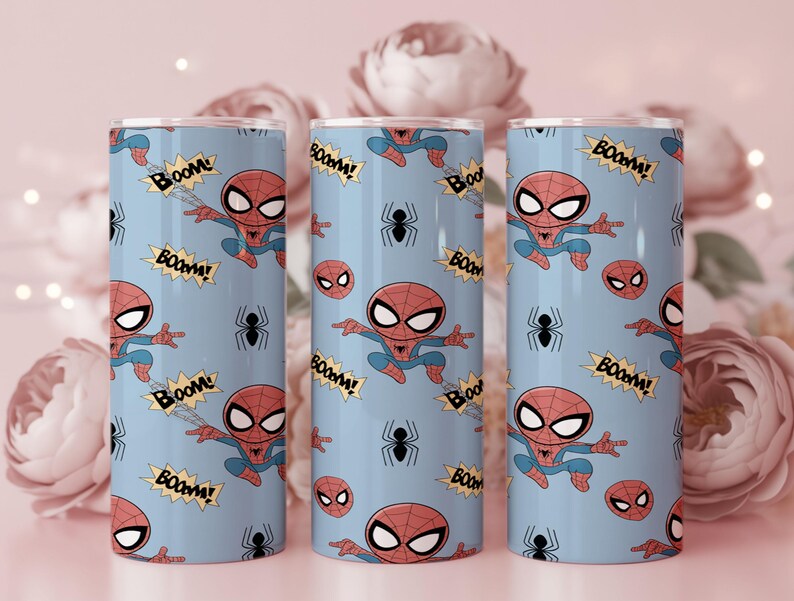 May include: Three blue tumblers featuring a repeating pattern of the Spider-Man character, spider webs, and the word "BOOM!" in yellow starbursts. The tumblers have a silver rim and lid, and are decorated with a cartoon style.