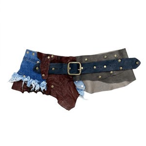 Op de afbeelding: Een brede riem opgebouwd uit een patchwork van blauwe denim met gerafelde randen, donkerbruin leer en grijze leren panelen. De riem is voorzien van een donkerblauwe leren band met een messingkleurige metalen gesp en kleine metalen klinknagels.