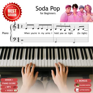 May include: A piano sheet music page titled Soda Pop for Beginners featuring a red Best Seller badge, an illustration of four people in pink, and musical notation with lyrics When you're in my arms I hold you so tight. Includes bonus labels.