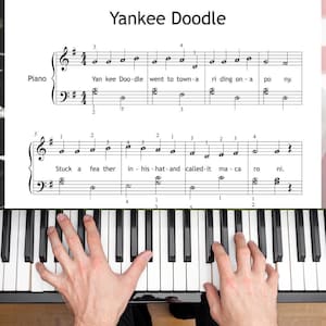 May include: A sheet music page titled Yankee Doodle for piano, featuring black musical notation on a white background with lyrics printed below the notes. The staff includes treble and bass clefs, time signatures, and finger numbering guides.