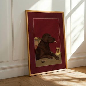 Könnte beinhalten: Gerahmter Kunstdruck mit einem braunen Hund, der eine Zigarette raucht, an einem Tisch mit einem Bierglas. Der Hintergrund ist rot und der Rahmen goldfarben. Das Kunstwerk ist im illustrativen Stil gehalten.