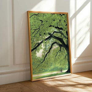 Può includere: Stampa artistica incorniciata raffigurante un grande albero verde con rami estesi, che ombreggia un sentiero dove un ciclista pedala. L'opera d'arte è in una cornice di legno, appoggiata a un muro bianco e un pavimento in legno.