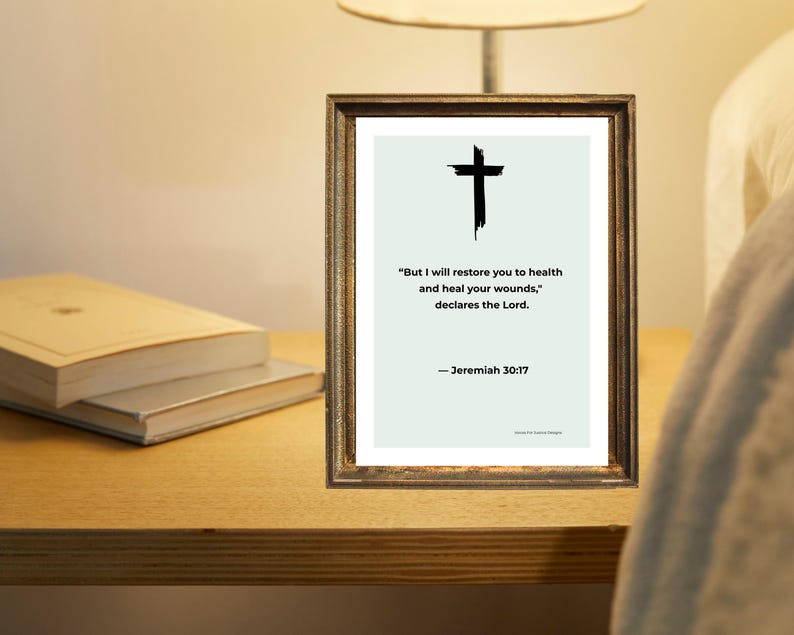 Puede incluir: Una impresi&oacute;n enmarcada con una cruz negra y la cita "Pero yo te restaurar&eacute; la salud, y sanar&eacute; tus heridas, dice el Se&ntilde;or." de Jerem&iacute;as 30:17. El marco es de color marr&oacute;n oscuro. Dos libros est&aacute;n sobre una superficie de madera.