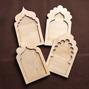 May include: Four light-colored wooden cutouts featuring arched window designs. Each piece has a smooth, flat surface with a distinct architectural silhouette, including pointed and scalloped top edges, crafted from natural wood with visible grain.