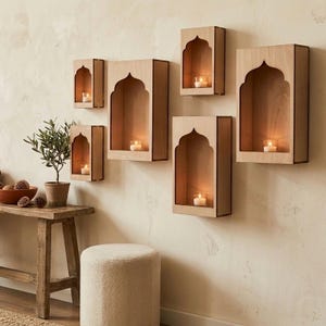 May include: A collection of six wooden wall shelves with an arched top design. Each shelf contains a lit candle in a glass holder. The shelves are mounted on a light-colored wall, creating a warm and inviting ambiance.