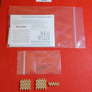 May include: A collection of Nolan Miller Glamour Collection jewelry pieces, including two square-shaped earrings and a smaller rectangular piece, all in a gold tone with embedded rhinestones. The image also shows a small bag of pins and a warranty card.