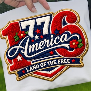 Könnte beinhalten: Gestickter Aufnäher mit patriotischem Design. Der Aufnäher zeigt die Zahl "76" in Weiß, das Wort "America" in blauer Schrift und den Satz "Land of the Free". Rote, weiße und blaue Farben mit goldenem Rand.