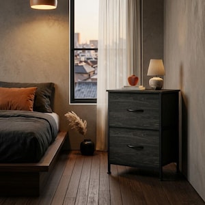 May include: A two-drawer nightstand featuring a dark wood grain finish, a black metal frame, and curved black handles. The unit stands on four short legs and supports a small lamp and a decorative orange object on its flat top surface.