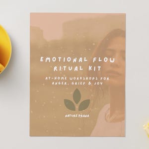 May include: A beige and brown kit with the text "EMOTIONAL FLOW RITUAL KIT" and "AT-HOME WORKSHOPS FOR ANGER, GRIEF & JOY." A woman's face is visible in the background. A yellow teacup and tray are in the image.