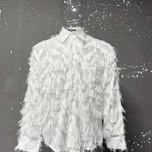 May include: A white shirt with long sleeves and a textured, fringed pattern. It features a collared neckline and button closure. The material looks lightweight, offering a flowing shape. The shirt is displayed on a mannequin.