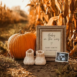 Może przedstawiać: Pomarańczowa dynia obok oprawionego znaku z napisem "Baby on the way" z sercem i imieniem "Baby Smith" oraz miesiącem "Październik 202X". Dwa małe, kremowe, dziergane buciki dla dziecka znajdują się przed dynią. Obok ramy znajduje się obraz USG.