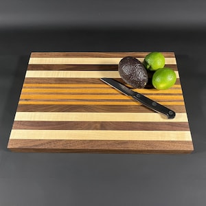 May include: A white ceramic mug with a black handle and the text "But First, Coffee" in a black, handwritten-style font. The mug is on a white surface.