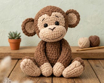 May include: A handmade crochet monkey in shades of brown and tan. The plush toy has a smiling face, large ears, and is sitting on a wooden surface. A small potted succulent and yarn balls are in the background.