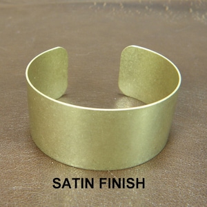 May include: A satin finish brass cuff bracelet. The bracelet is a simple, solid band with no embellishments.
