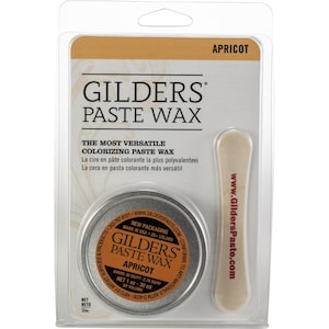 May include: Apricot-colored Gilders Paste Wax in a metal tin, packaged with a wooden applicator. The label reads "Gilders Paste Wax" and "The Most Versatile Colorizing Paste Wax". The net weight is 1 oz (30 ml).