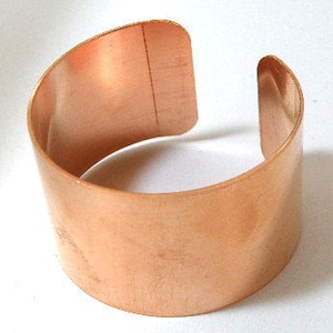May include: A simple copper cuff bracelet with a smooth, polished finish.