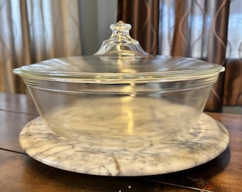 Cazuela Pyrex 026 de 25 cm (10") con tapa y recipiente de vidrio transparente para servir.