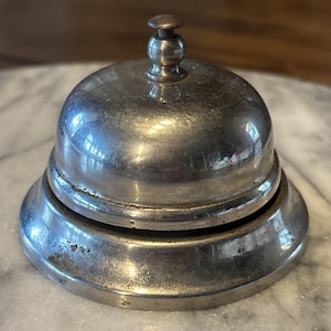 Mostrador de recepción de hotel antiguo VTG con grifo de campana y pátina de metal.