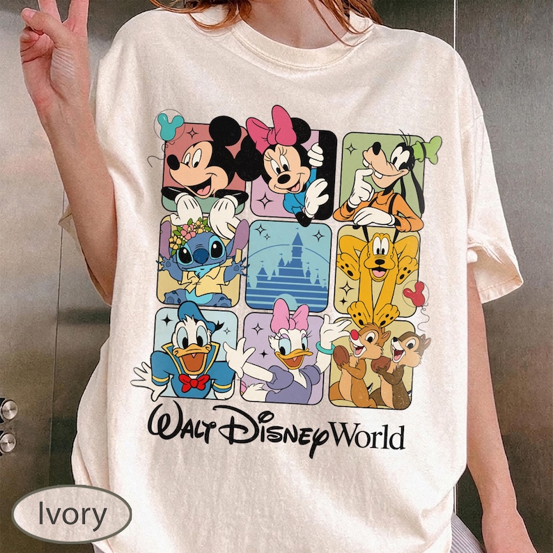 May include: Ivory-colored t-shirt featuring a grid of Disney characters including Mickey Mouse, Minnie Mouse, Goofy, Stitch, Pluto, Donald Duck, Daisy Duck, Chip and Dale. The words "Walt Disney World" are printed below the grid.