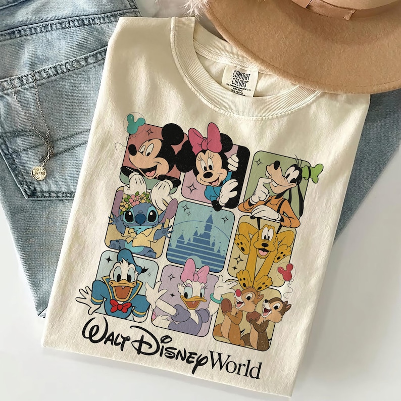May include: Cream-colored t-shirt featuring a grid of Disney characters including Mickey, Minnie, Goofy, Stitch, Donald Duck, Daisy, Chip, and Dale. The words "Walt Disney World" are printed in black script at the bottom.