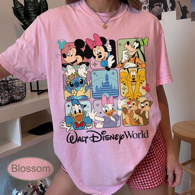May include: A light pink t-shirt featuring a grid of Disney characters including Mickey Mouse, Minnie Mouse, Goofy, Stitch, Donald Duck, Daisy Duck, Chip and Dale. The words "Walt Disney World" are printed below the grid.